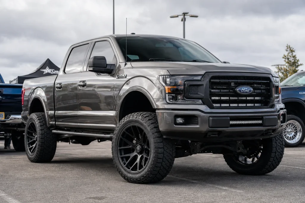 Lifted Ford F150 with matte black 20x10 wheels and all terrain tires