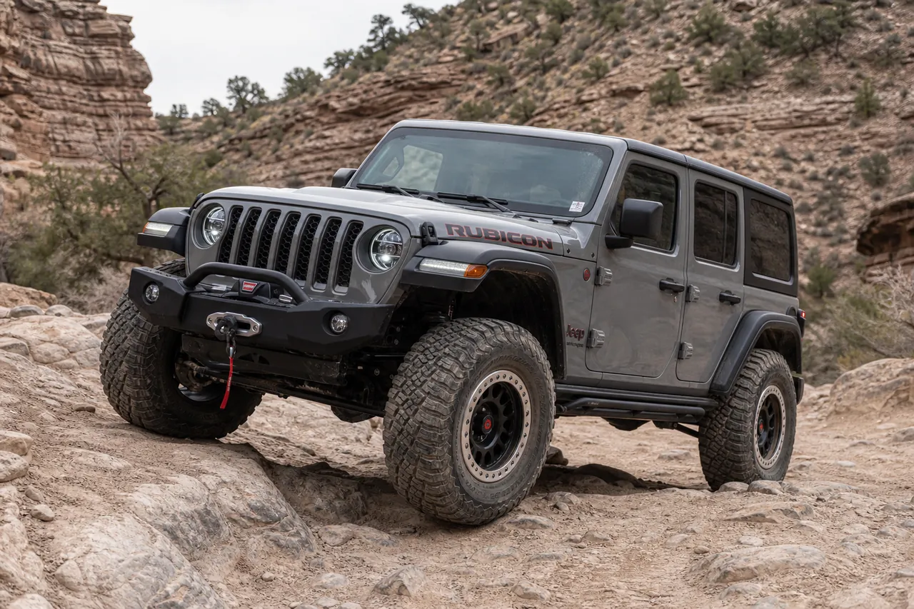 Best Jeep Wrangler Wheels for a Strong Off Road Setup Jeep Wrangler off road wheel setup climbing a mild rocky trail